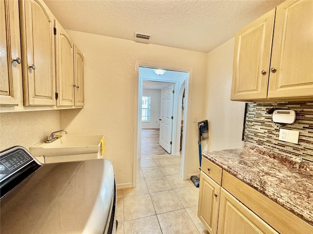 6522 Pimlico St, North Port, FL 34291 - washroom with washer / dryer, cabinet space, a textured ceiling, and light tile patterned floors