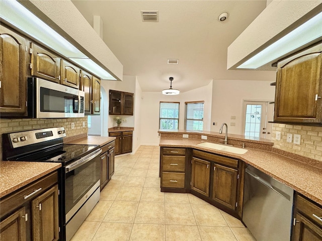 6522 Pimlico St, North Port, FL 34291 - kitchen featuring stainless steel appliances, tasteful backsplash, light tile patterned floors, and a peninsula
