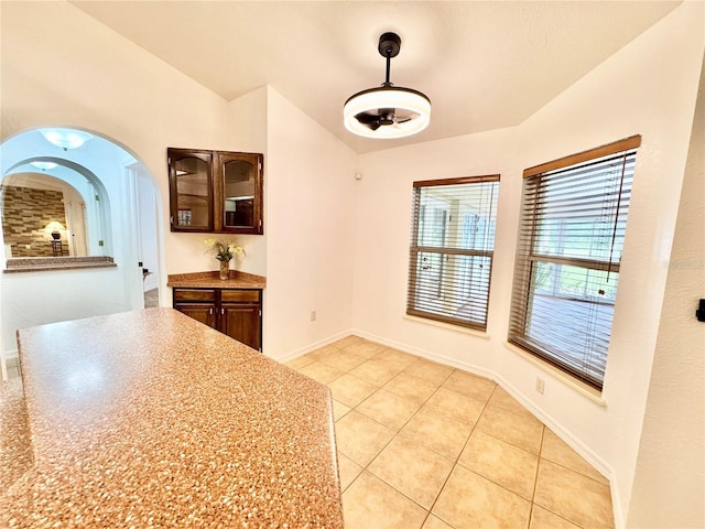 6522 Pimlico St, North Port, FL 34291 - unfurnished dining area featuring lofted ceiling, light tile patterned floors, and arched walkways