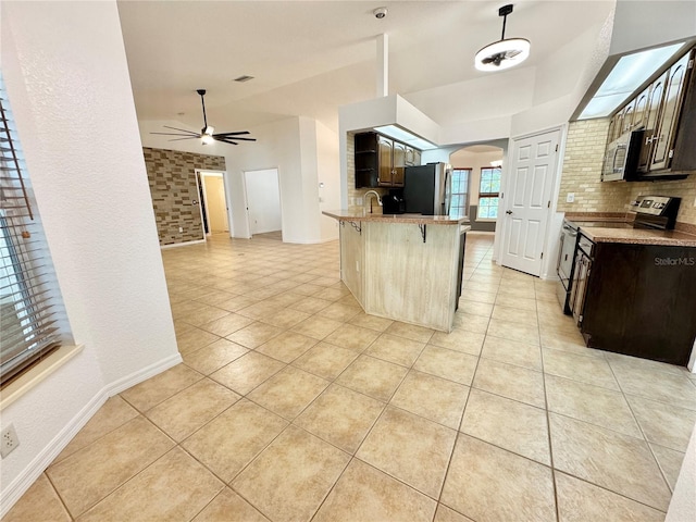 6522 Pimlico St, North Port, FL 34291 - kitchen featuring stainless steel appliances, arched walkways, a breakfast bar, light tile patterned floors, and a ceiling fan