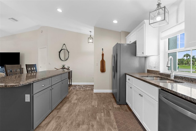 108 Albatross Rd, Rotonda West, FL 33947 - kitchen with appliances with stainless steel finishes, dark stone countertops, white cabinetry, hanging light fixtures, and vaulted ceiling