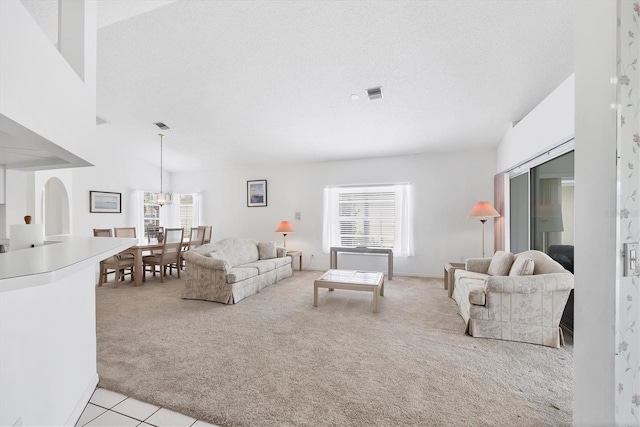 1429 Turnberry Dr, Venice, FL 34292 - living room featuring light carpet, healthy amount of natural light, a chandelier, light tile patterned floors, and a textured ceiling