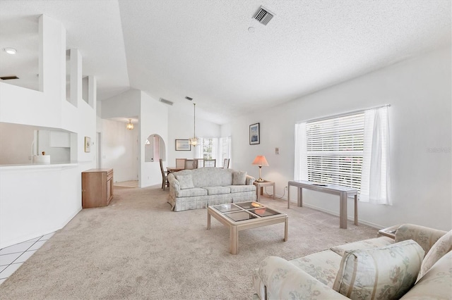 1429 Turnberry Dr, Venice, FL 34292 - living area with a textured ceiling, arched walkways, light carpet, a chandelier, and high vaulted ceiling