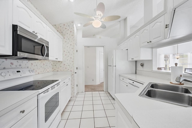 1429 Turnberry Dr, Venice, FL 34292 - kitchen featuring white appliances, white cabinets, ceiling fan, wallpapered walls, and light countertops