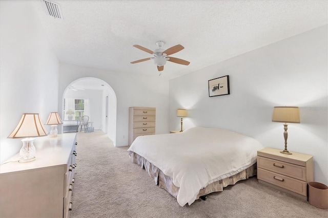 1429 Turnberry Dr, Venice, FL 34292 - bedroom with light carpet, arched walkways, a textured ceiling, and ceiling fan