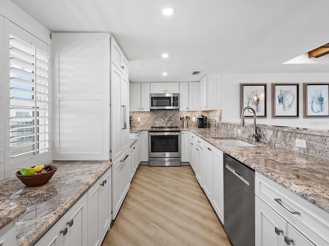 6300 Midnight Pass Rd Unit 809, Sarasota, FL 34242 - kitchen with stainless steel appliances, recessed lighting, white cabinetry, light stone countertops, and light wood-style floors