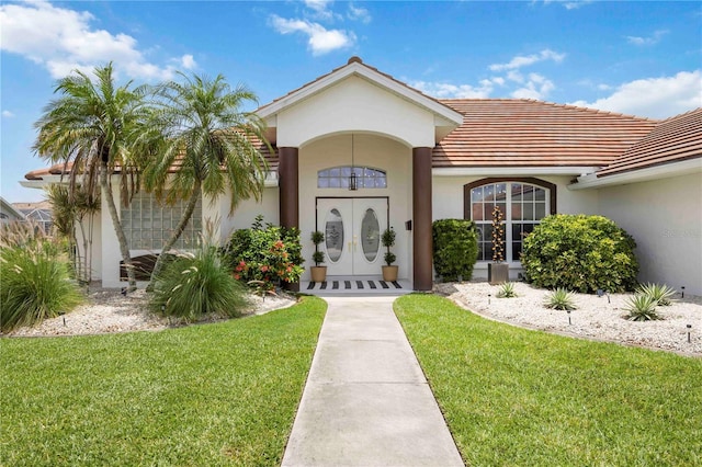 5028 Greenway Ct, North Port, FL 34287 - property entrance featuring a lawn, stucco siding, and a tile roof