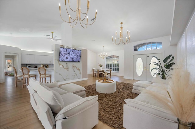 5028 Greenway Ct, North Port, FL 34287 - living room with a chandelier, lofted ceiling, light wood-style flooring, and a ceiling fan
