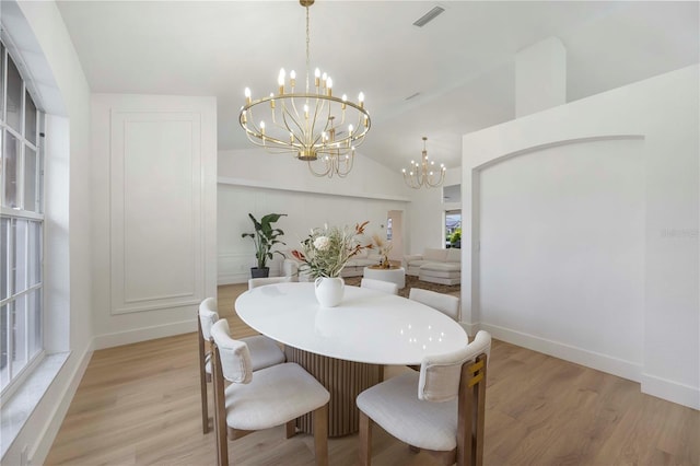 5028 Greenway Ct, North Port, FL 34287 - dining area with a chandelier, light wood-style flooring, and lofted ceiling