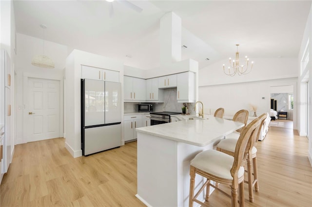 5028 Greenway Ct, North Port, FL 34287 - kitchen with freestanding refrigerator, black microwave, a peninsula, electric range, and a chandelier