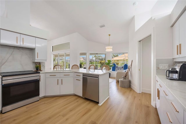 5028 Greenway Ct, North Port, FL 34287 - kitchen with stainless steel appliances, light countertops, white cabinetry, backsplash, and a peninsula