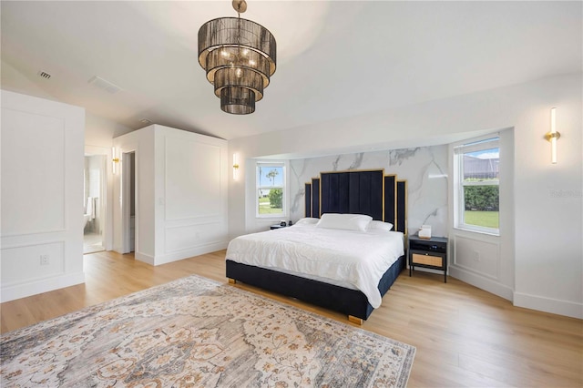 5028 Greenway Ct, North Port, FL 34287 - bedroom with multiple windows, light wood-type flooring, and a chandelier