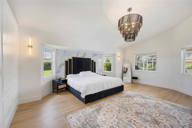 5028 Greenway Ct, North Port, FL 34287 - bedroom featuring multiple windows, light wood-style flooring, vaulted ceiling, and a chandelier