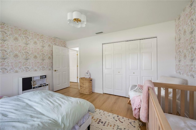 5028 Greenway Ct, North Port, FL 34287 - bedroom with wallpapered walls, wood finished floors, and a closet