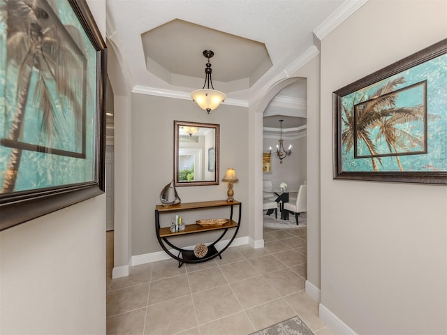 141 Bella Vista Ter Unit 34B, North Venice, FL 34275 - corridor featuring arched walkways, light tile patterned floors, ornamental molding, a raised ceiling, and a chandelier