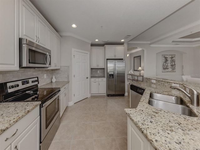 141 Bella Vista Ter Unit 34B, North Venice, FL 34275 - kitchen featuring appliances with stainless steel finishes, ornamental molding, light tile patterned floors, backsplash, and white cabinets
