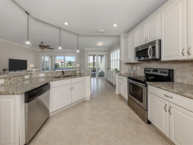 141 Bella Vista Ter Unit 34B, North Venice, FL 34275 - kitchen featuring appliances with stainless steel finishes, white cabinets, light tile patterned floors, backsplash, and open floor plan