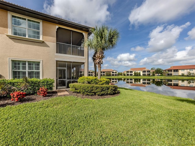141 Bella Vista Ter Unit 34B, North Venice, FL 34275 - rear view of house featuring stucco siding, a water view, and a yard