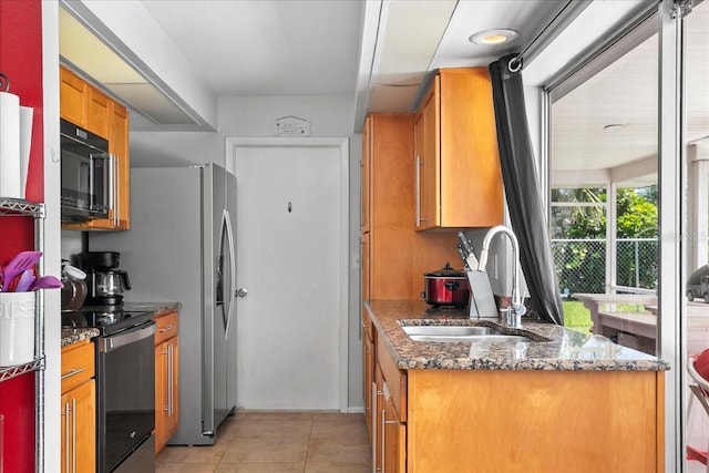 18671 Macgill Ave, Port Charlotte, FL 33948 - kitchen featuring black microwave, stainless steel range with electric stovetop, brown cabinets, light tile patterned flooring, and dark stone countertops