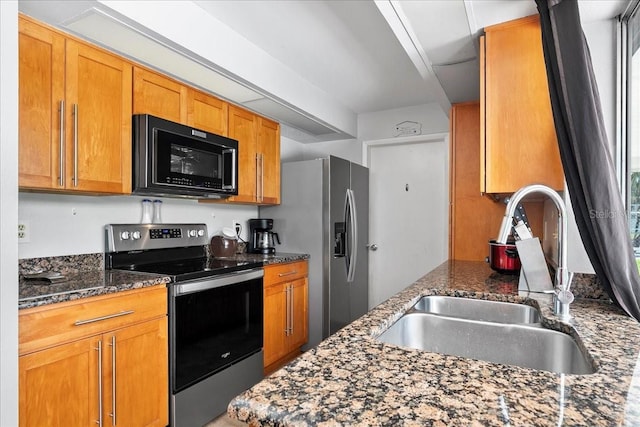 18671 Macgill Ave, Port Charlotte, FL 33948 - kitchen featuring stainless steel appliances, dark stone counters, and brown cabinets