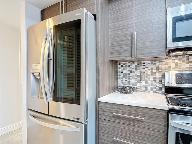 1335 Rock Dove Ct Unit 111, Punta Gorda, FL 33950 - kitchen featuring appliances with stainless steel finishes, modern cabinets, tasteful backsplash, and light countertops