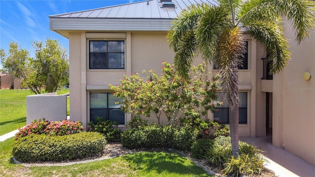 1335 Rock Dove Ct Unit 111, Punta Gorda, FL 33950 - view of home's exterior featuring a standing seam roof, stucco siding, a metal roof, and a yard
