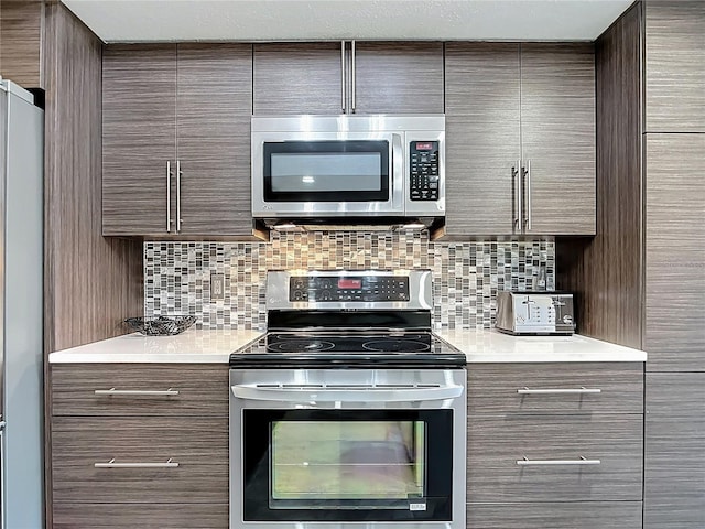 1335 Rock Dove Ct Unit 111, Punta Gorda, FL 33950 - kitchen with appliances with stainless steel finishes, modern cabinets, light countertops, and backsplash