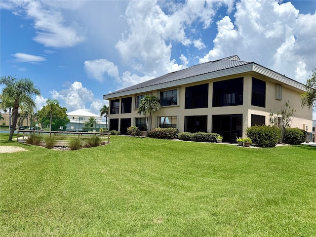 1335 Rock Dove Ct Unit 111, Punta Gorda, FL 33950 - back of property with a yard, stucco siding, and a metal roof