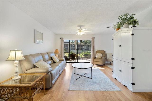 752 White Pine Tree Rd Unit 108, Venice, FL 34285 - living area with a textured ceiling, a ceiling fan, and light wood-type flooring