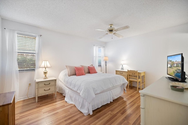 752 White Pine Tree Rd Unit 108, Venice, FL 34285 - bedroom with multiple windows, light wood-style flooring, a textured ceiling, and a ceiling fan