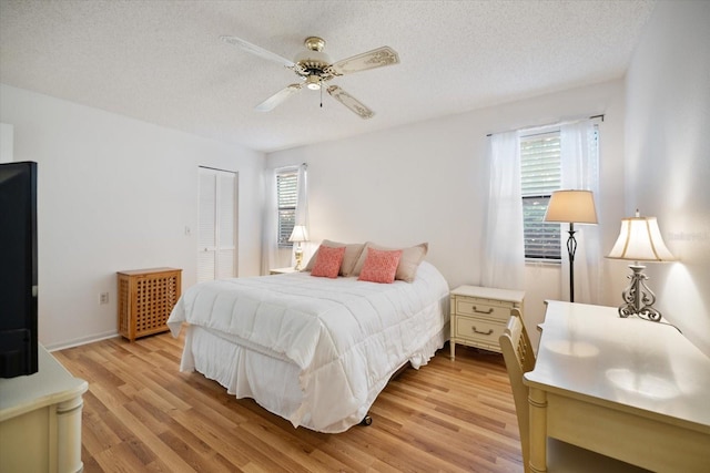 752 White Pine Tree Rd Unit 108, Venice, FL 34285 - bedroom featuring multiple windows, light wood finished floors, a closet, a textured ceiling, and a ceiling fan
