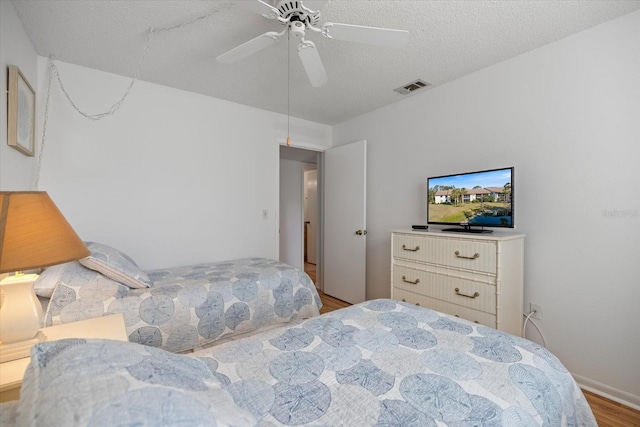 752 White Pine Tree Rd Unit 108, Venice, FL 34285 - bedroom with wood finished floors, a textured ceiling, and a ceiling fan