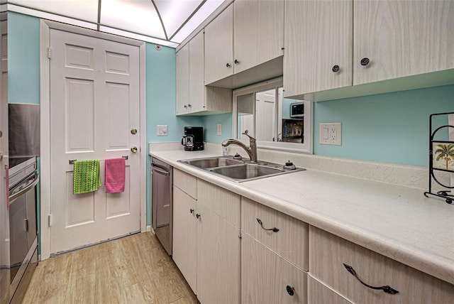 200 The Esplanade N Unit B19, Venice, FL 34285 - kitchen featuring appliances with stainless steel finishes, light countertops, and light wood-type flooring
