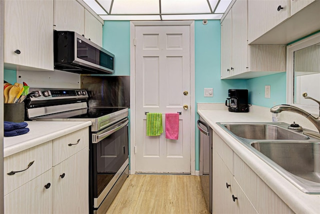 200 The Esplanade N Unit B19, Venice, FL 34285 - kitchen featuring appliances with stainless steel finishes, light wood finished floors, and light countertops