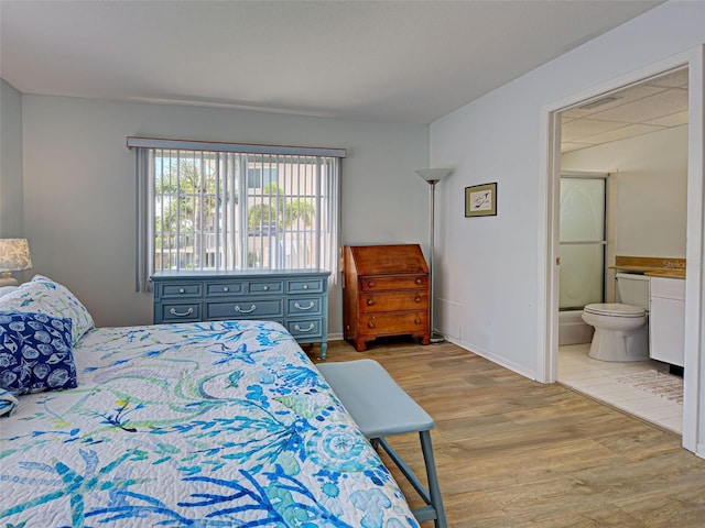200 The Esplanade N Unit B19, Venice, FL 34285 - bedroom with wood finished floors and ensuite bath
