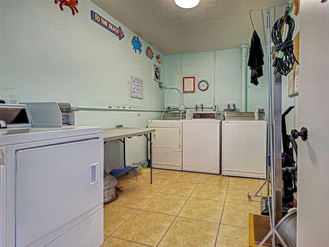 200 The Esplanade N Unit B19, Venice, FL 34285 - community laundry with washer and clothes dryer, light tile patterned flooring, and a textured ceiling