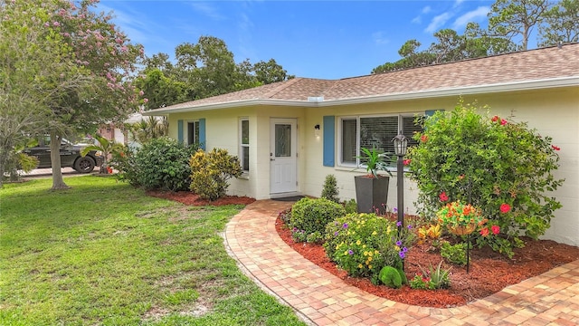 3274 Savage Rd, Sarasota, FL 34231 - entrance to property with roof with shingles, a lawn, and concrete block siding