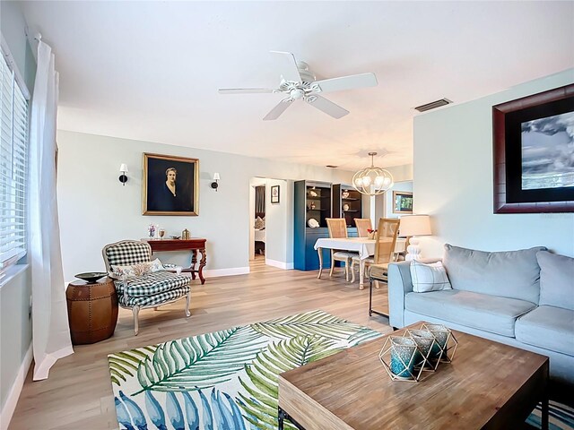 3274 Savage Rd, Sarasota, FL 34231 - living room with light wood-type flooring, a ceiling fan, and a chandelier