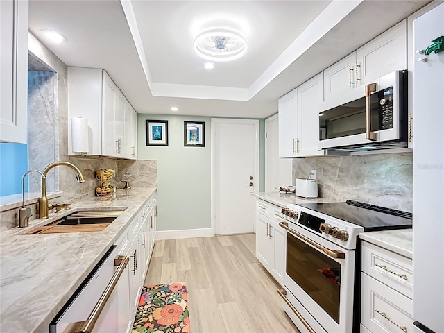 3274 Savage Rd, Sarasota, FL 34231 - kitchen with white appliances, decorative backsplash, white cabinets, light wood-type flooring, and recessed lighting