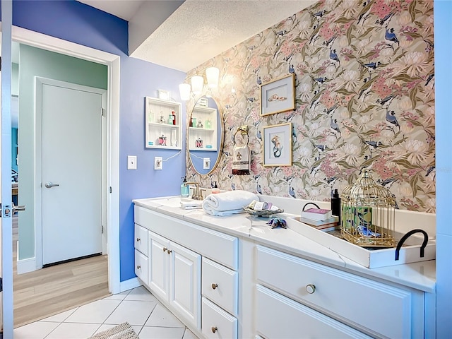3274 Savage Rd, Sarasota, FL 34231 - bathroom featuring double vanity, tile patterned floors, wallpapered walls, and a textured ceiling