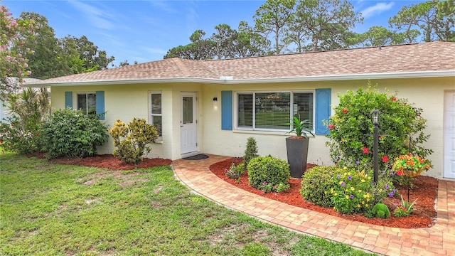 3274 Savage Rd, Sarasota, FL 34231 - ranch-style house featuring a shingled roof, a front yard, and concrete block siding