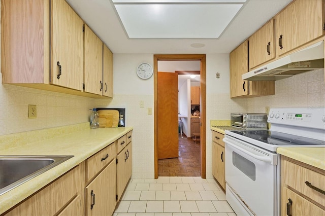 12001 Daroco Ln, North Port, FL 34287 - kitchen featuring electric stove, under cabinet range hood, light countertops, light brown cabinets, and backsplash