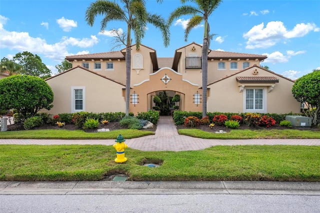 114 Bella Vista Ter Unit 6C, Nokomis, FL 34275 - mediterranean / spanish-style house with stucco siding, a tile roof, and a front lawn