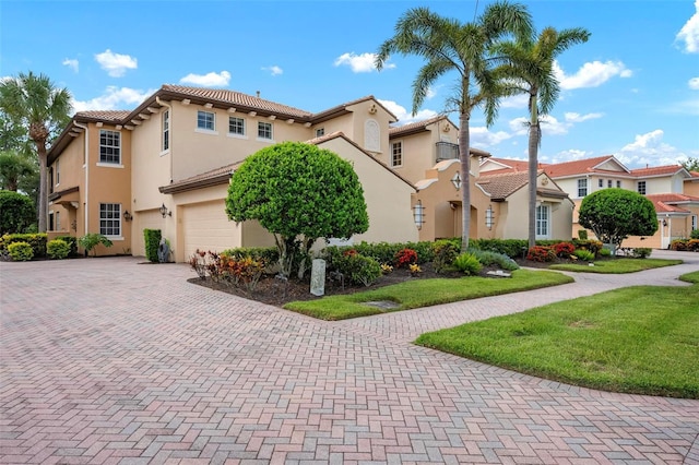 114 Bella Vista Ter Unit 6C, Nokomis, FL 34275 - mediterranean / spanish-style home featuring a garage, decorative driveway, stucco siding, and a tile roof