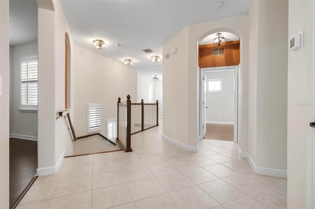 114 Bella Vista Ter Unit 6C, Nokomis, FL 34275 - hall featuring an upstairs landing, arched walkways, healthy amount of natural light, and light tile patterned floors