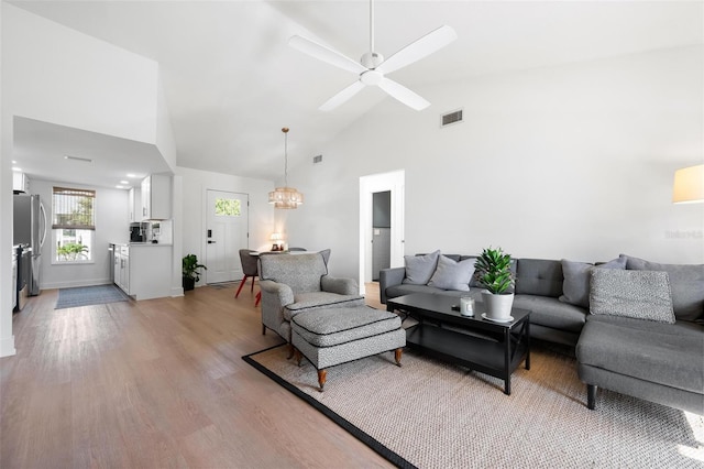 812 Garland Ave, Nokomis, FL 34275 - living room with light wood-style flooring, high vaulted ceiling, a ceiling fan, and a chandelier