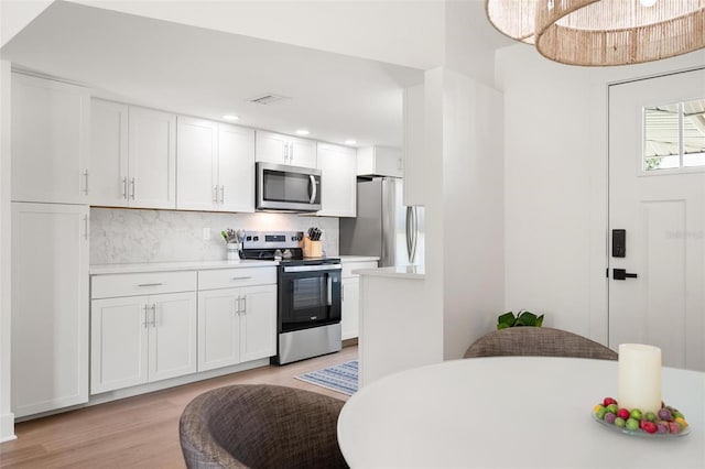 812 Garland Ave, Nokomis, FL 34275 - kitchen featuring appliances with stainless steel finishes, light countertops, backsplash, light wood-style floors, and recessed lighting