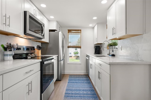 812 Garland Ave, Nokomis, FL 34275 - kitchen featuring stainless steel appliances, tasteful backsplash, recessed lighting, white cabinets, and light wood-style floors