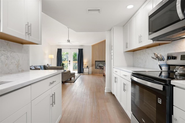 812 Garland Ave, Nokomis, FL 34275 - kitchen featuring appliances with stainless steel finishes, tasteful backsplash, ceiling fan, open floor plan, and light wood finished floors