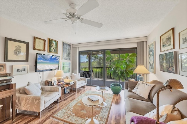 1088 Bird Bay Way Unit 307, Venice, FL 34285 - living area with a textured ceiling, wood finished floors, and ceiling fan